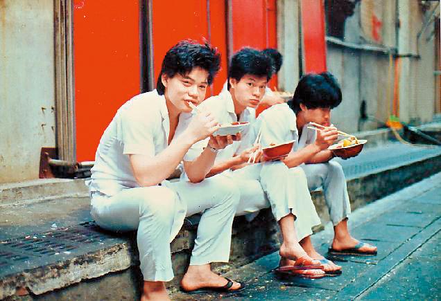 林志成（左1）18歲在蓮園餐廳當廚師，下班後與同事坐在路邊吃飯。（林志成提供）