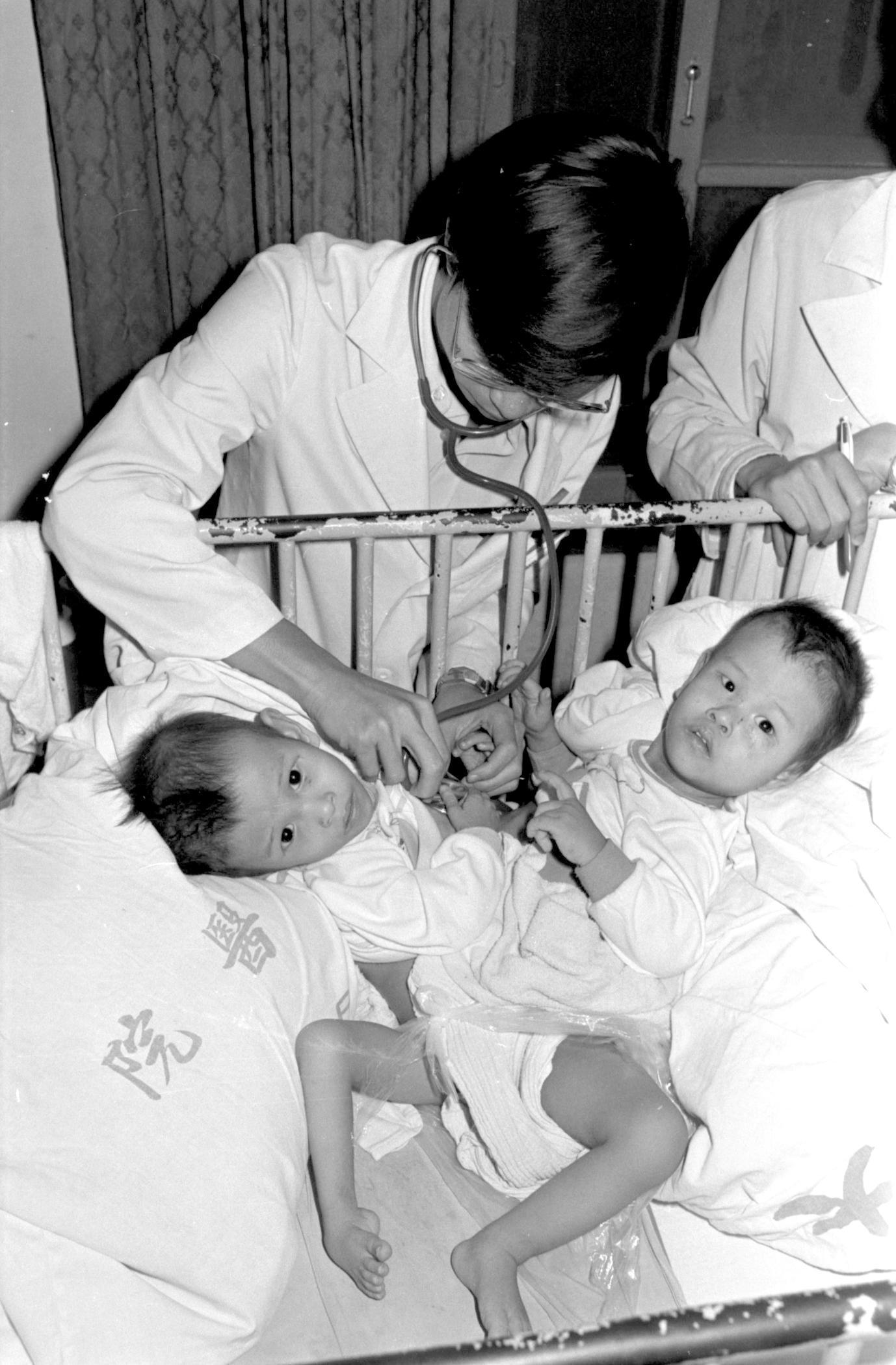 尚未分割前的忠仁（左）、忠義（右），當時即將2歲，在台大醫院接受檢查。（中央社）