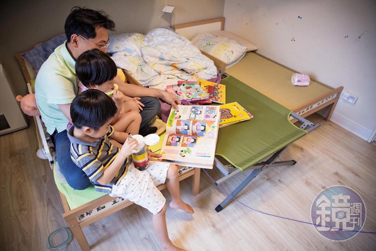 假日的午後，先生劉大經（後）陪雙胞胎小海豹（中）、小鯨魚（前）一起讀故事書。
