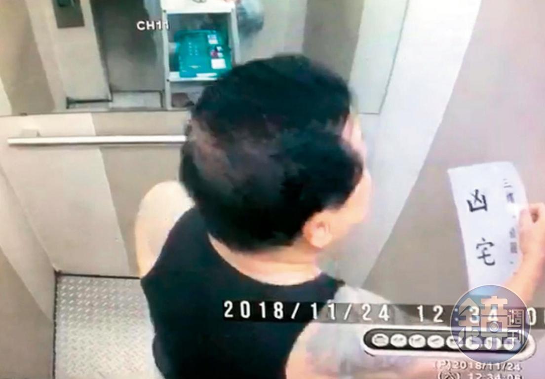 戴崇慶不滿住戶對他霸住行為提出檢舉，拿著凶宅標語在電梯間噴漆，警告意味濃厚。（讀者提供）