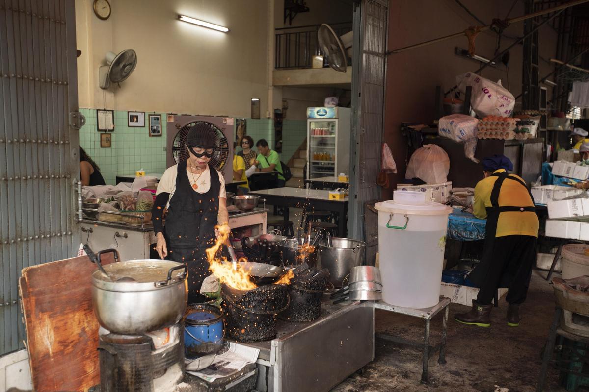 泰國Jay Fai餐廳的蟹肉蛋捲，不僅拿下米其林一星，老闆娘Supinya Junsuta戴著護目鏡大火快炒，也是最搶眼的人物。（Netflix提供）