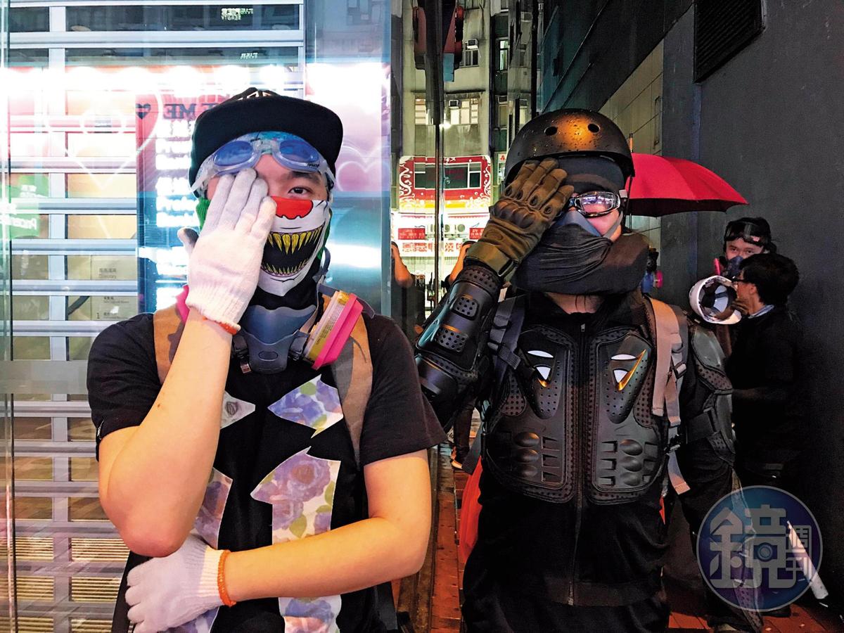 2名勇武派示威者遮住右眼，讽刺警方射伤香港民众眼睛。（陈虹瑾摄）