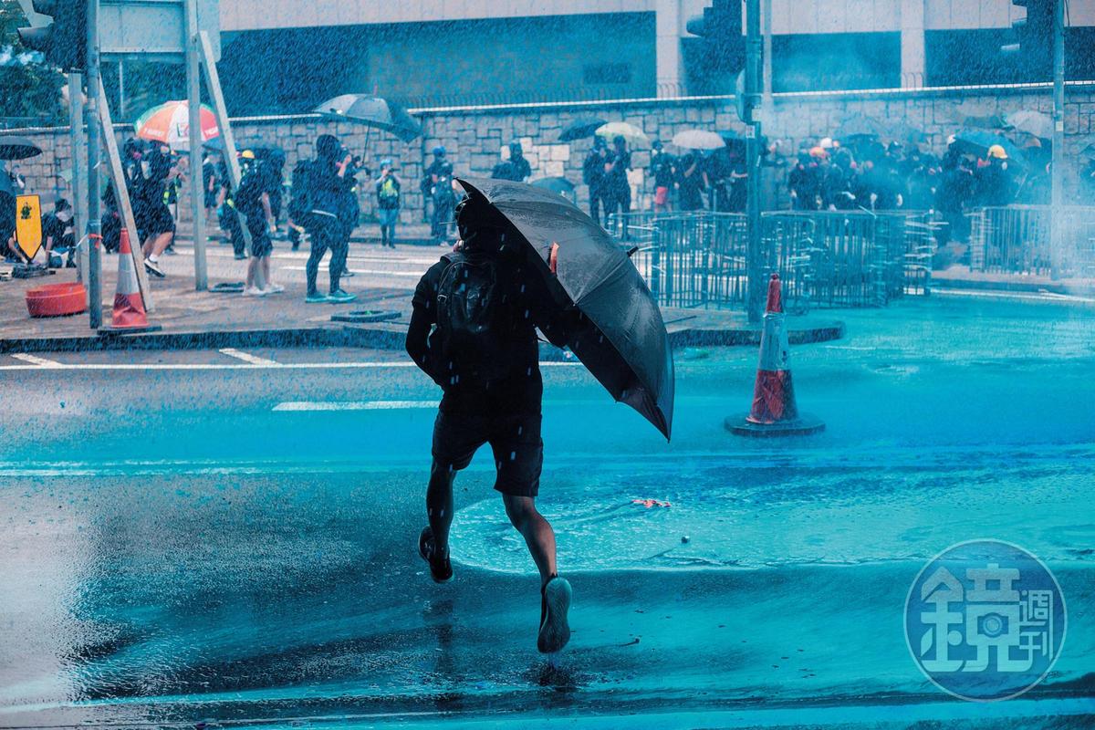 港警首度出动喷出蓝色液体的水炮车，示威者纷纷走避。
