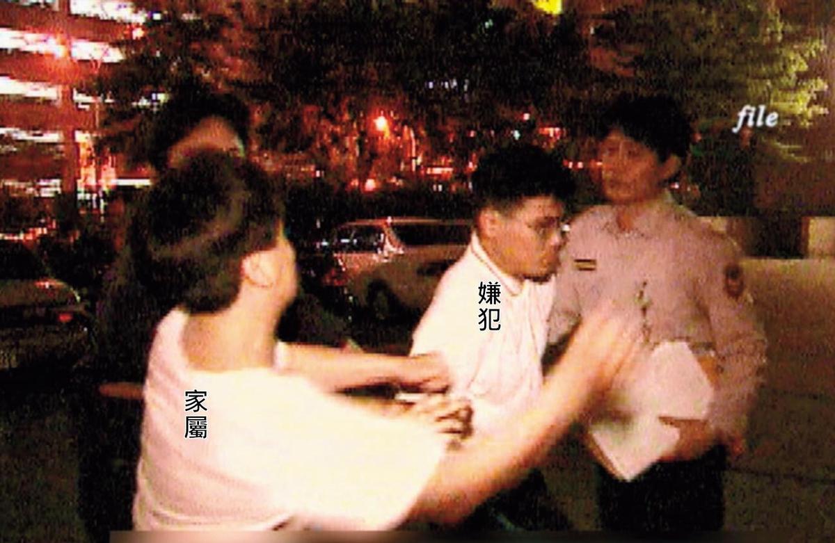 狠心殺害小姊妹的陳昆明被警方移送時，遭家屬揮拳教訓。（東森新聞提供）