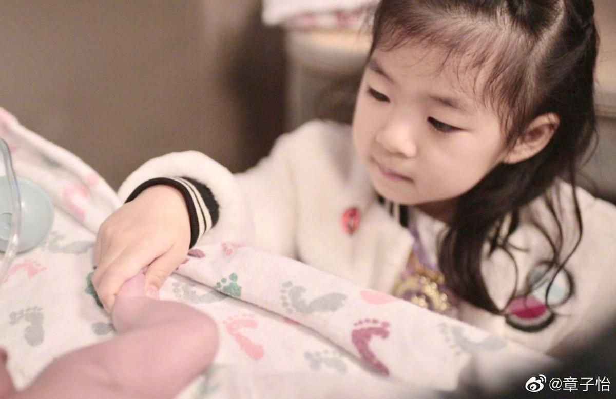 章子怡與汪峰的女兒醒醒溫柔輕握著弟弟的小手。（翻攝自章子怡微博）
