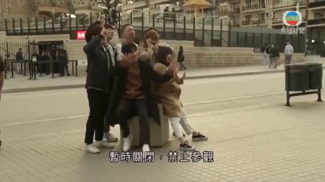 銀赫與友人在馬德里拍照恰巧被香港電視台拍進新聞畫面。（翻攝影片）