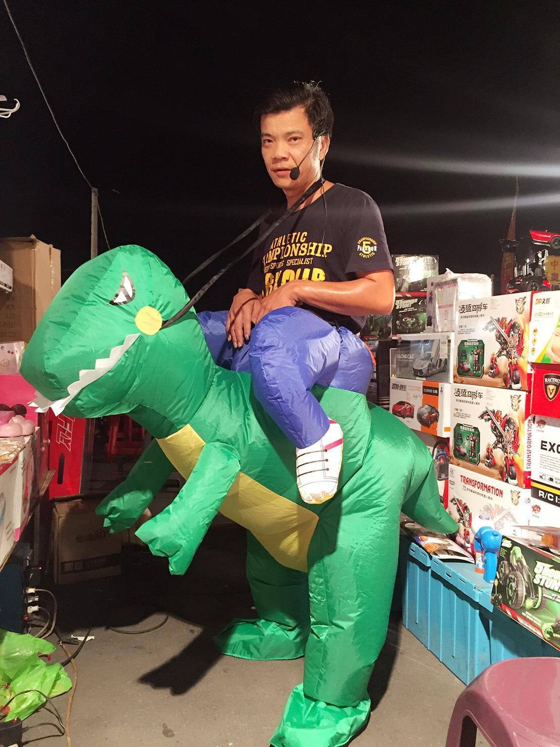 王三郎騎著恐龍在員林龍燈夜市賣玩具。（王三郎提供）