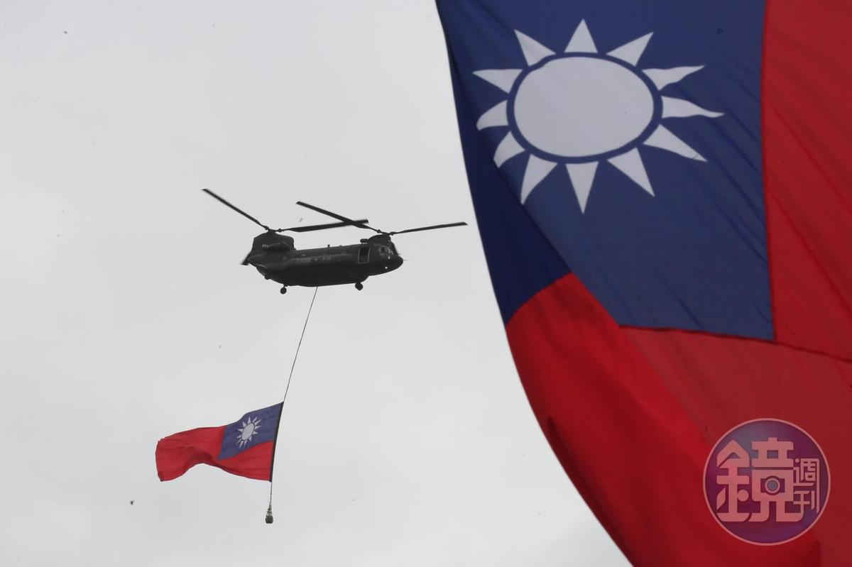 國歌領唱時，運輸直升機吊掛巨型國旗飛越總統府前。