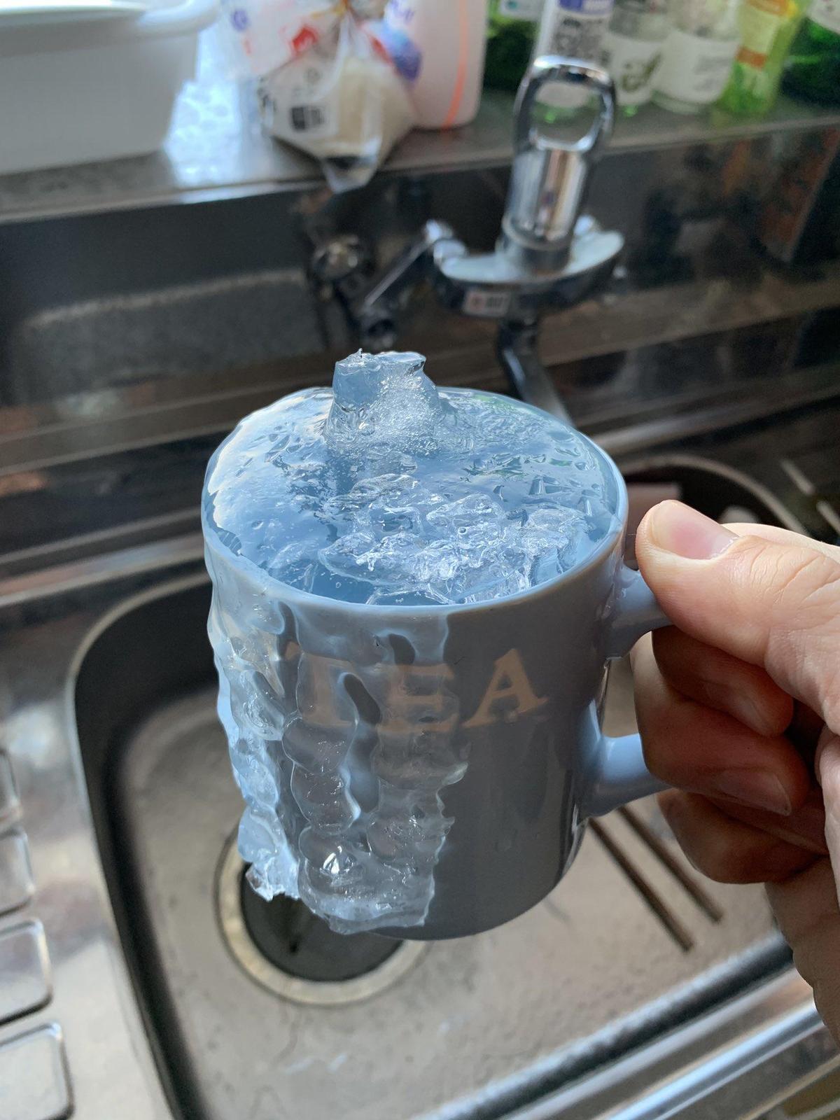 原po還補上結冰馬克杯照片，只見杯身溢出的水也跟著結冰，他搞笑自嘲「它已變成新的設計了」。（翻攝自@hasetaku推特）