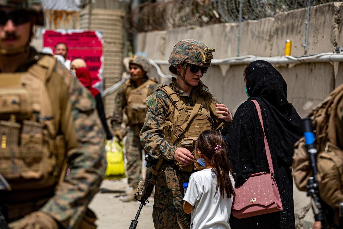 美軍於機場護送撤離人員，並加強篩檢與盤查；圖為美軍協助阿富汗婦女及女童。（翻攝自美國國防部推特）