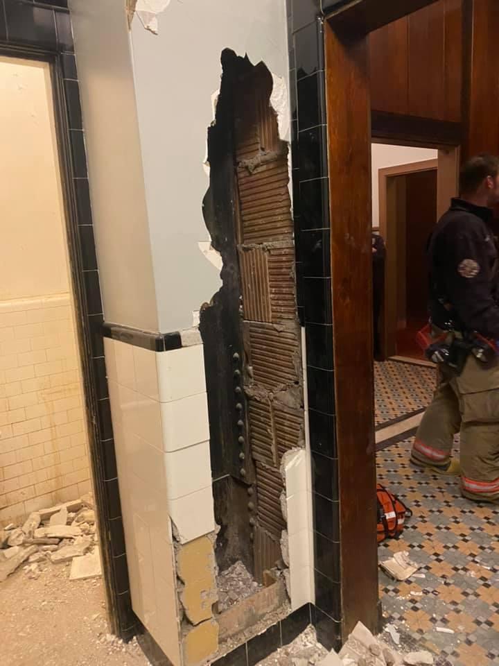 劇院廁所的牆內傳出敲擊求救聲，警方破牆後發現一名男子躲在裡面。（翻攝Syracuse Fire Department臉書）