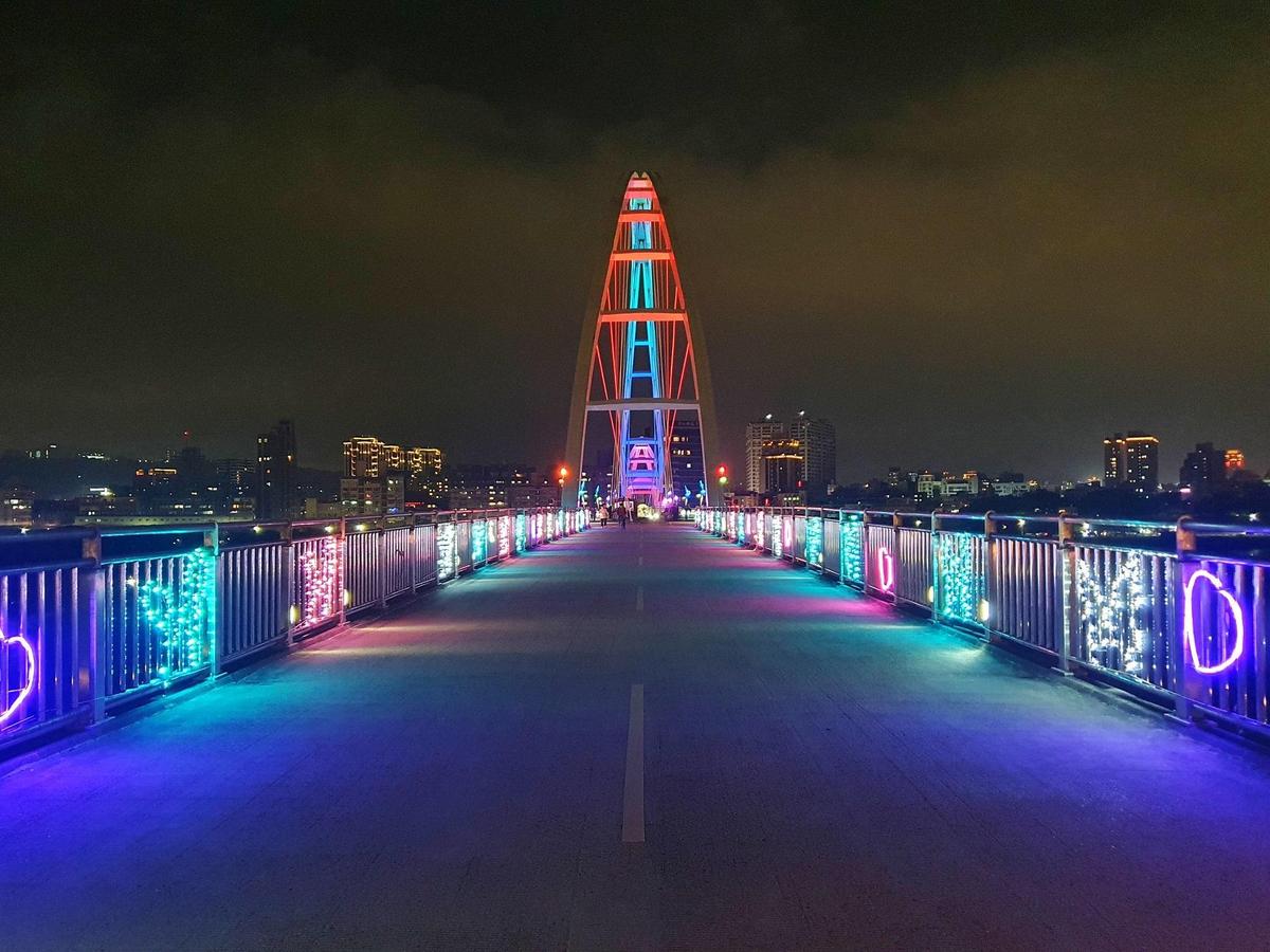  新月橋欄杆掛上繽紛的LED燈串，為新月橋增添許多浪漫氛圍。（新北市政府高灘地工程管理處提供）