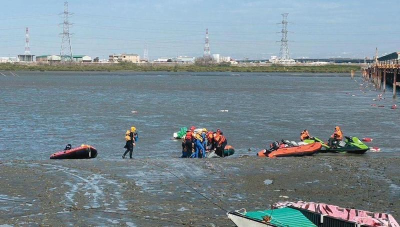 海巡人員在海岸邊打撈偷渡客浮屍。（海巡署提供。圖／鏡週刊）