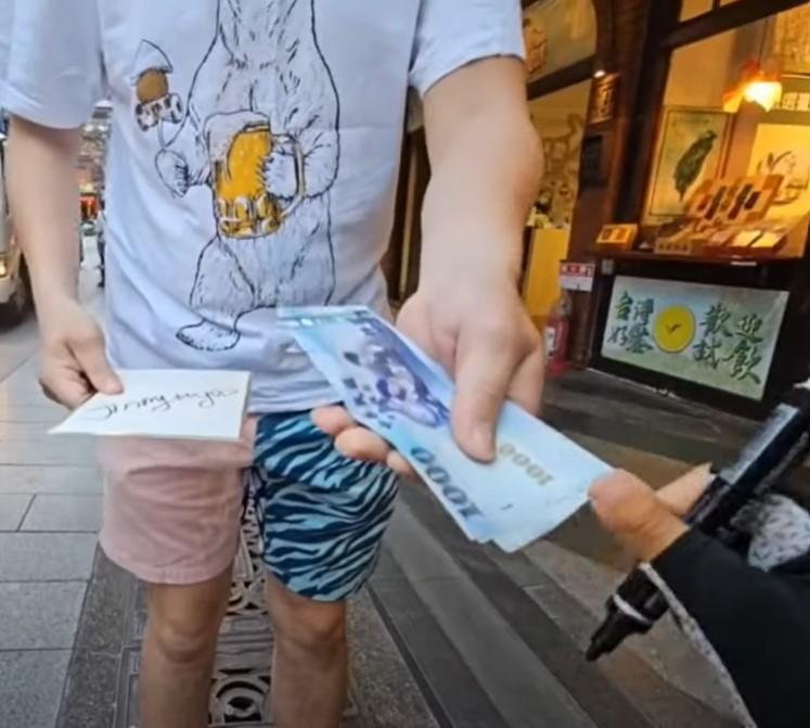 企鵝妹環島路過三峽老街幫粉絲簽名，對方竟掏出3張千元鈔票「現場抖內」讓她又驚又喜。（翻攝自文組新聞室 YT頻道）