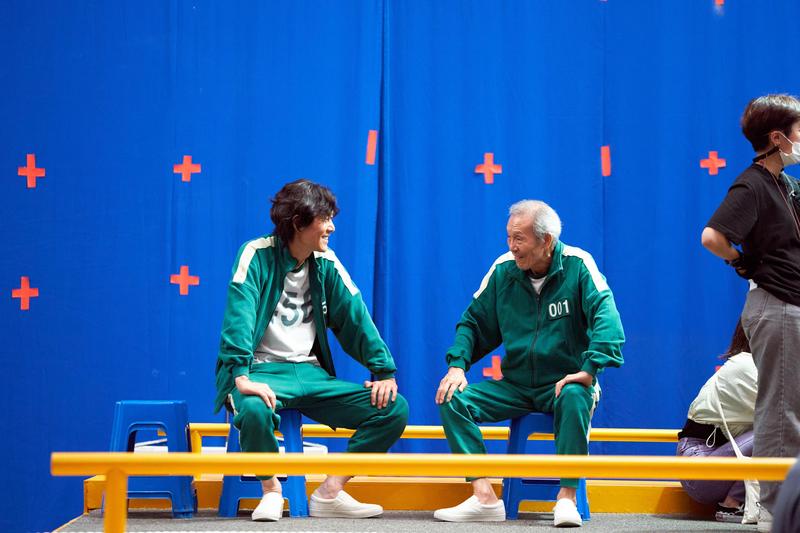 李政宰（左）主演的韓劇《魷魚遊戲》有許多遊戲場景都是在藍幕前面拍攝，再靠後製特效完成。（Netflix提供）