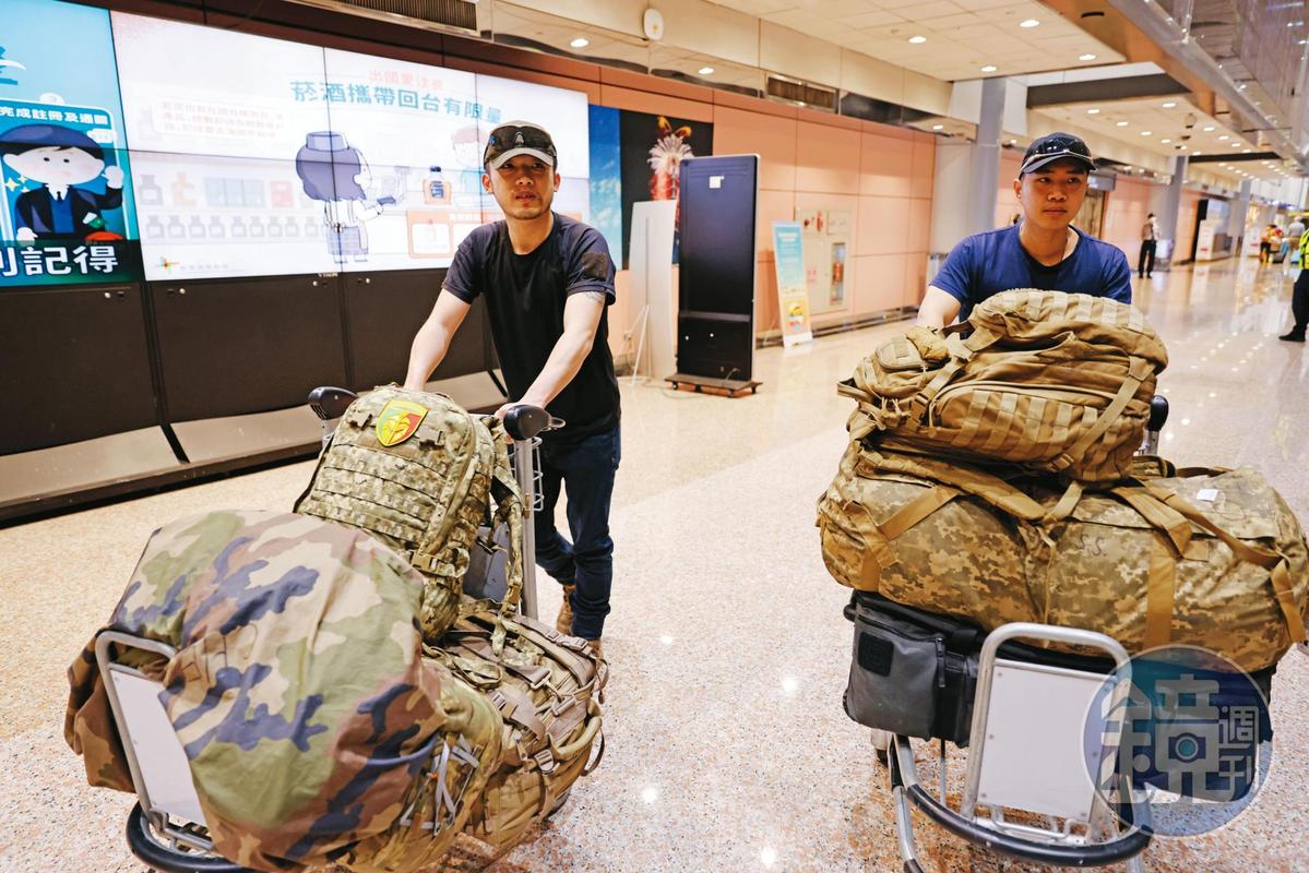 5月23日陳晞（右）與戰友Cai（左）一同返抵國門。Cai行李上貼著他們所屬國際兵團的臂章