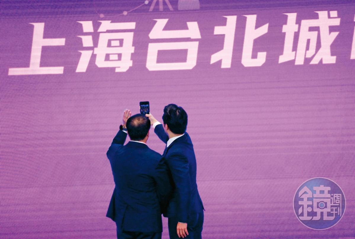 雙城論壇8月30日在上海舉辦，蔣萬安（右）在台上拿起手機拍照，留下紀念。（圖／鏡周刊提供）